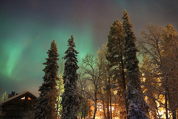 Northern light above a cabin in the woods stock photo