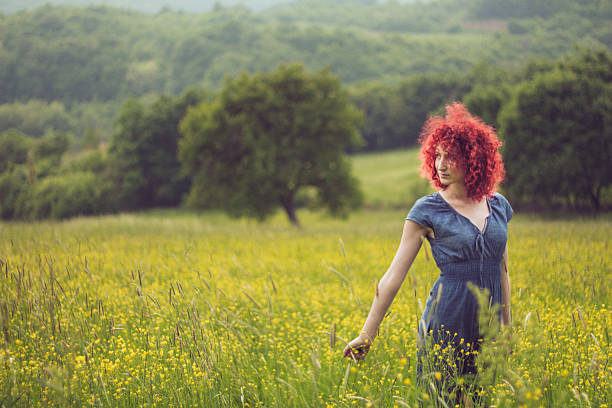 istock Gorgeous red haired beauty walking among flowery meadow 531318378