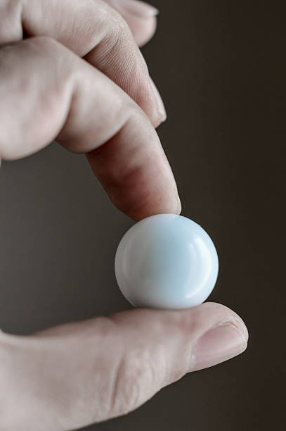 istock fingers holding a white glass sphere 531319164