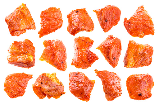 Pieces of raw pork isolated on white background. Chunks of barbecue in a sauce isolated with a clipping path.