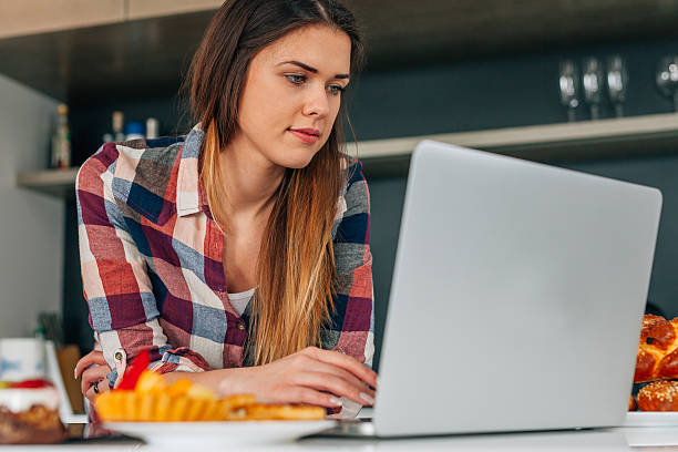 istock Young beutiful woman using laptop in the kithcen. 531320648