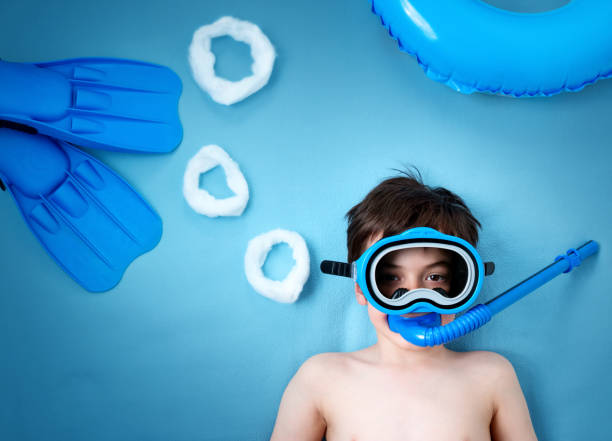 istock Child lying on blue blanket with swimming mask 531321480