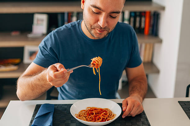 Young man eating spaghetti bolognese. stock photo