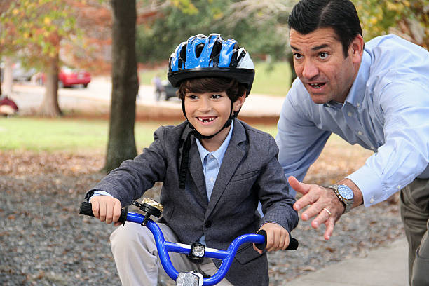 istock Father is helping his son keeping his balance in park 531324578