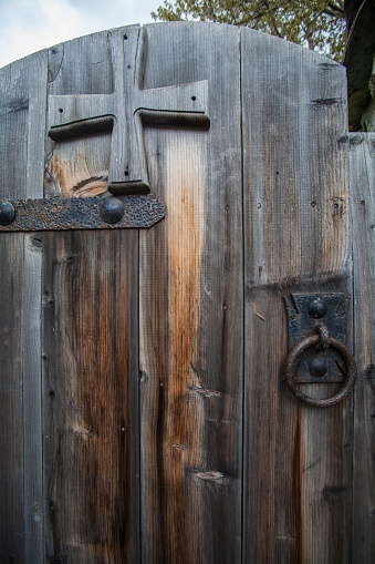An old gate with handle and a cross in the Svaneti mountain village in Republic of Georgia