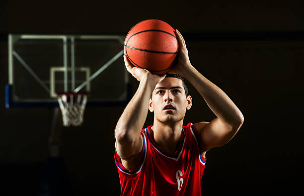 Basketball player. Front view of basketball player shooting at the hoop. making a basket scoring stock pictures, royalty-free photos & images