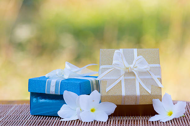 Colorful gift boxes  on wooden mat on meadow background