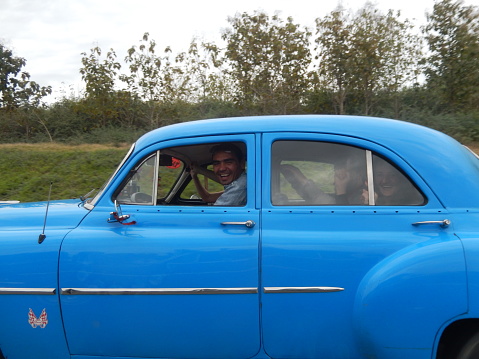Highway Havana-Pinar del Rio, Cuba - January 21, 2016: A cheerful group of tourists singing and waving their hands while travelling from Havana to Vinales, Cuba