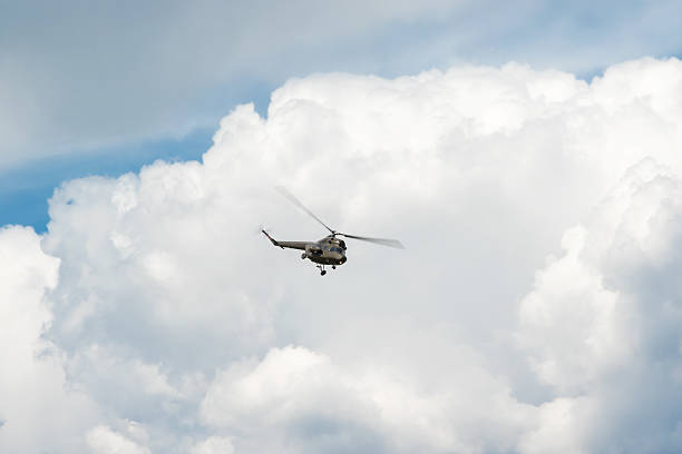 istock Green helicopter in the blue sky 531330154