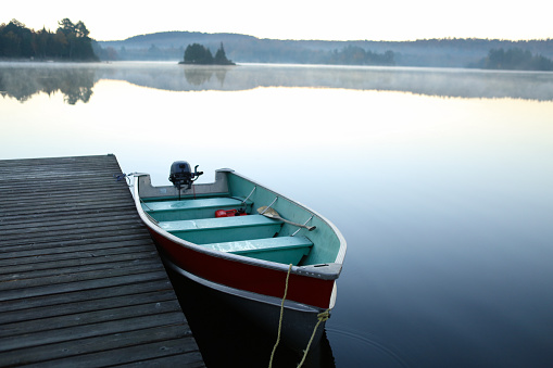 calm lake at sunrise with boat