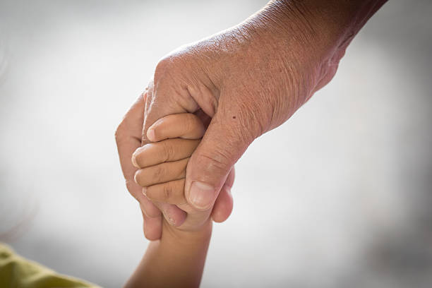 istock Old woman and kid holding hand together 531334941