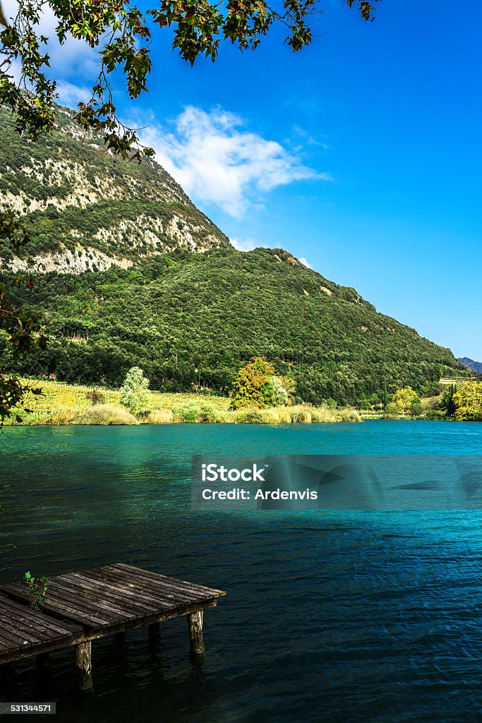 Plateau in legno davanti al lago di montagna Toblino, Italia - Foto stock royalty-free di 2015