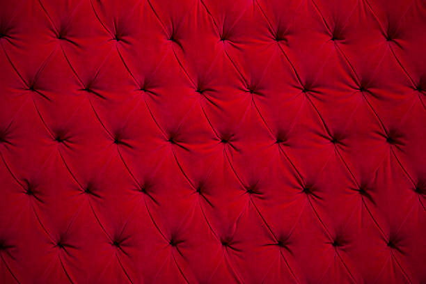 Red quilted plush velvet couch The back of a vintage red velvet couch with quilted back. Horizontal with copy space. red velvet material stock pictures, royalty-free photos & images
