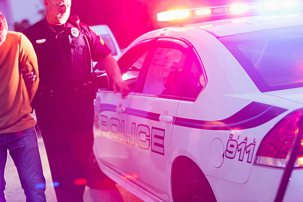 istock Police officer arresting a young man at night 531347803