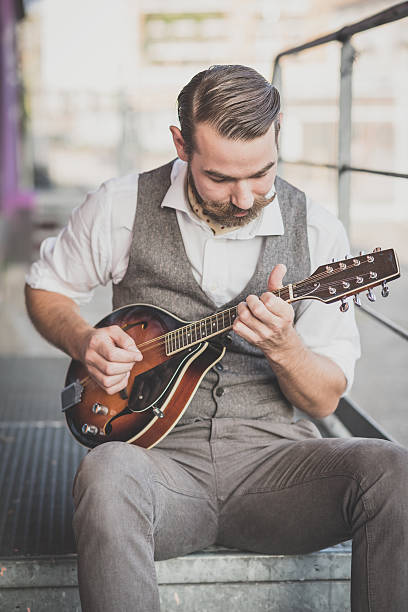 handsome big moustache hipster man playing mandolin