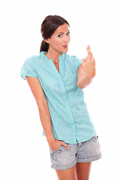 Charming lady with crossing fingers for luck sign while looking at you in white background