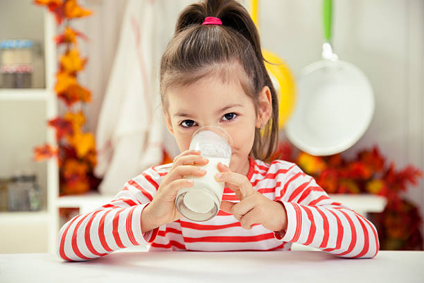 petite fille à boire un verre de lait - milk child drinking little girls photos et images de collection