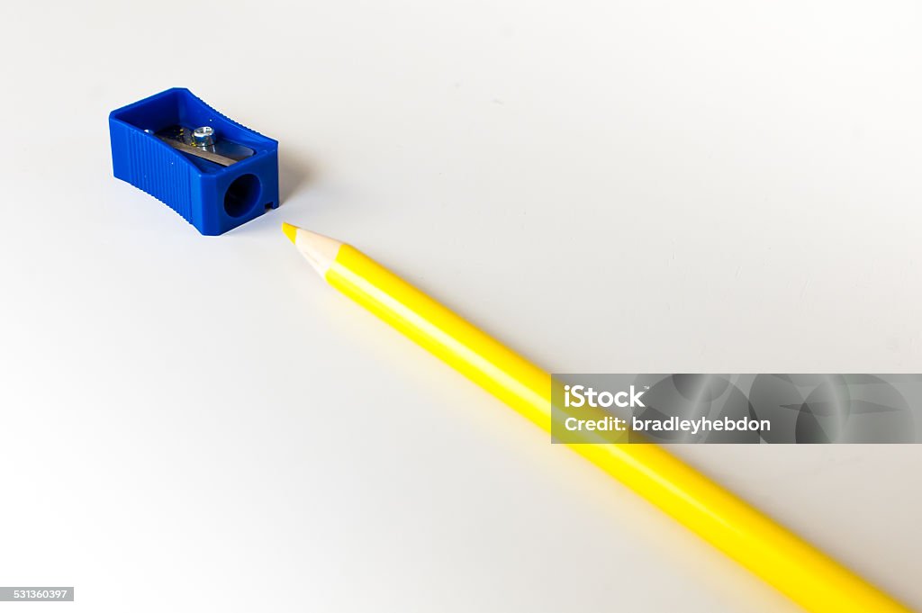 Yellow pencil and blue sharpener against white Sharpened yellow pencil and blue sharpener lie isolated on a white surface, facing each other. The pencil is about to be inserted into the sharpener, or has just been removed. There's plenty of room for copy within this clean and minimalistic composition. 2015 Stock Photo