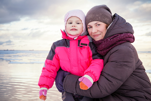 Caucasian family outdoor portrait on the winter sea coast, young