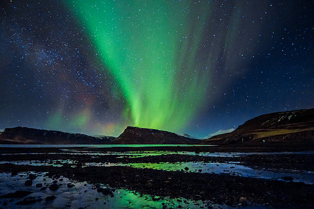 A typical Nordic nightscape and very famous location for travelers and adventurers from all over the world - Iceland with the spectacular celestial lights Aurora Borealis above into the winter night sky and amazing water reflection of the Norther lights, which makes Polar country popular spot for tourists willing to witness one of the greatest natural phenomenoms. Shot with Canon EOS 60D, wide 11mm angle lens, f2.8, ISO 1600, long exposure of 25 seconds.