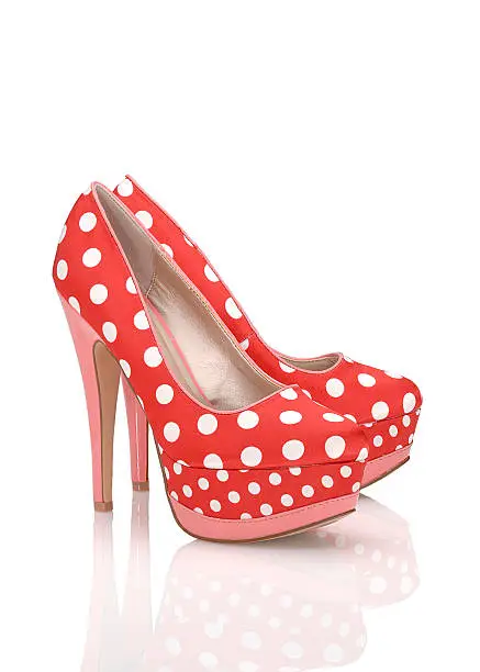 Fashionable red-colored High Heels shoe with peep toe, Isolated on white, plexiglass tabletop, copy space, red colored, white polkadots, women's pumps, pink heels