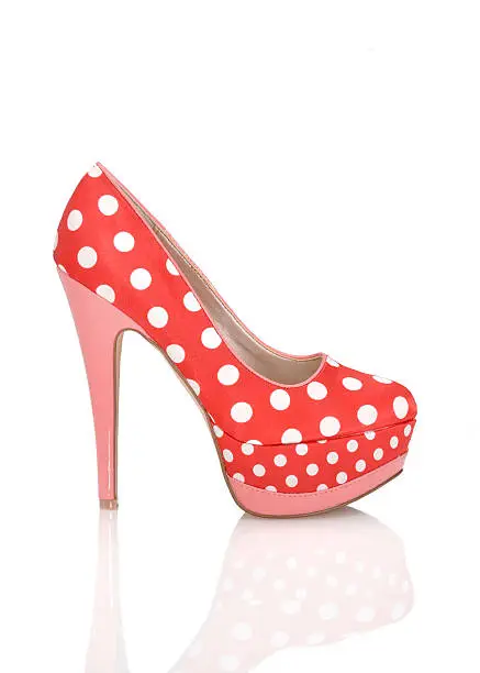 Fashionable red-colored High Heels shoe with peep toe, Isolated on white, plexiglass tabletop, copy space, red colored, white polkadots, women's pumps, pink heels