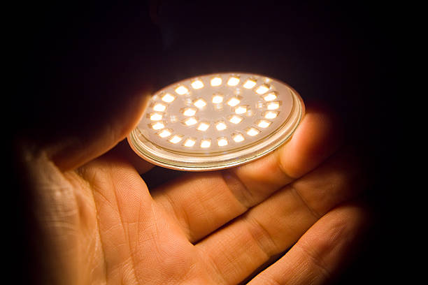 Energy saving light bulb on a black background with free space for text. Saving energy and finances. Electrical equipment and the evolution of light. Free space for text
