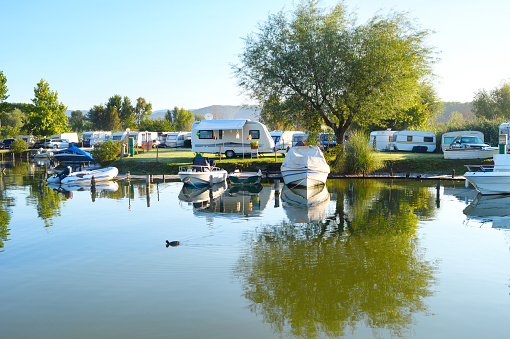 Camping site on a lake with caravans and boats