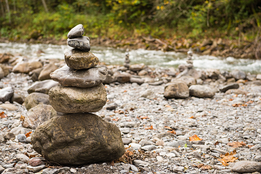 Stones in balance on top each other in front of a river
