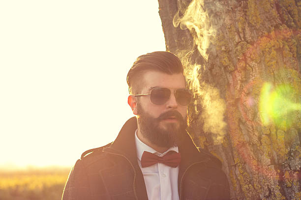 istock Sad hipster guy smokes outdoors in field 531383901