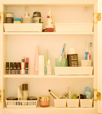Inside a simple, and organized, bathroom cabinet. This cabinet is over the sink.