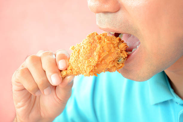 istock Man eating fried chicken leg or drumstick 531385663