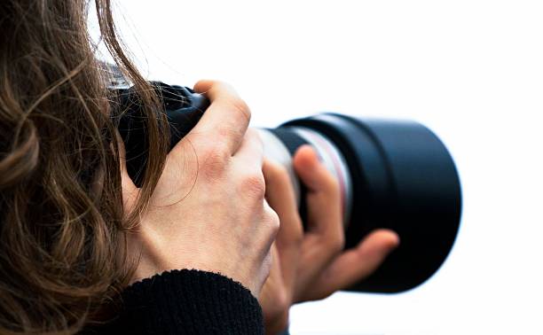 istock Closeup Photographer holding camera isolated on white background, copy space 531386785