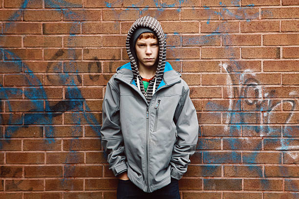 istock Teen Boy Leans Against Brick Wall With Graffiti 531386949