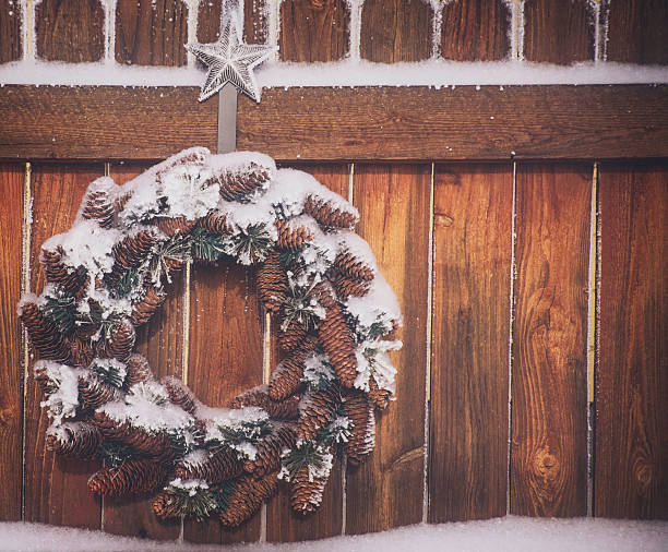 istock Christmas wreath hanging on rustic fencing in snow 531387513