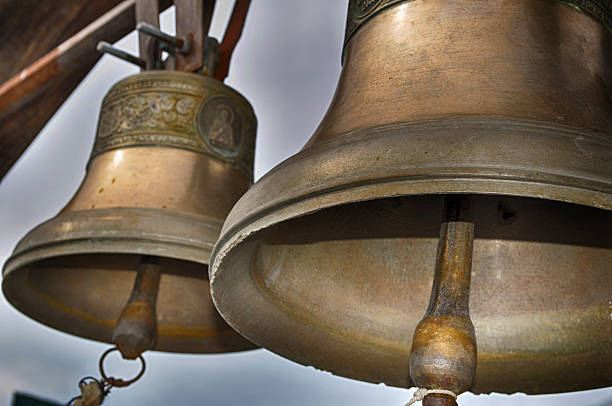 two bronze bells two bronze bells on the background of cloudy sky bell photos stock pictures, royalty-free photos & images