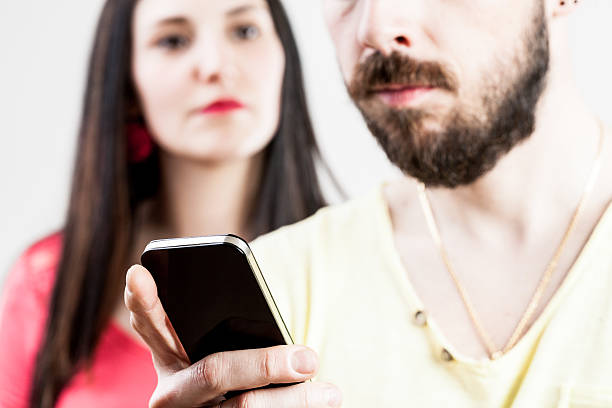woman disappointed about his man on his mobile woman disappointed with his man watching a smartphone or texting divergent movie review stock pictures, royalty-free photos & images