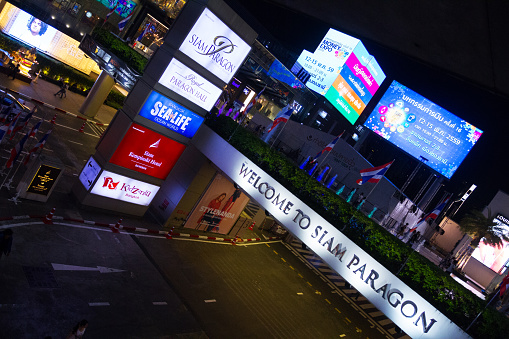 Bangkok, Thailand - May 15, 2016: Night shot of banners at Siam Paragon and Siam Center malls. On left area is Siam Center. In bottom area is entrance to parking. Some people are in scene.