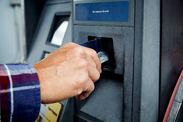 Mans Hand inserting Credit Card at ATM at Gas Pump stock photo