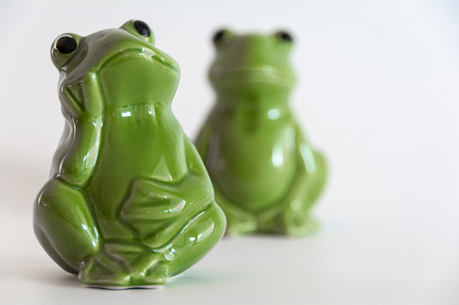 Green ceramic frog salt and pepper shakers on a white background.