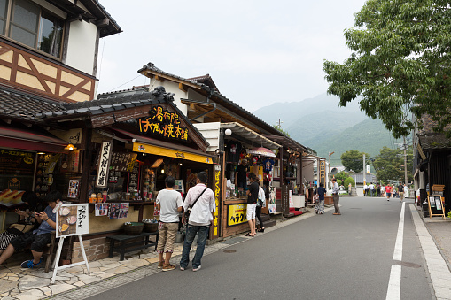 Yufu, Japan - September 2, 2014 : People walk past the Yufuin Shopping Street in Oita Prefecture, Japan. Yufuin is a popular hot spring resort in Japan. The shopping street is full of souvenir shops, cafes and boutiques.