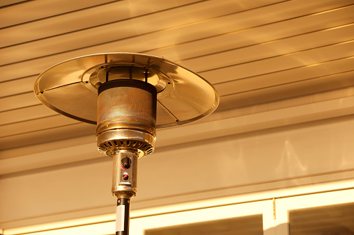 Outdoor heater on the terrace in a tourist resort in Italy. Horizontal color photo.