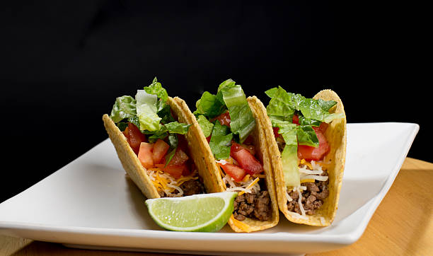 istock Hard-shelled tacos with meat, cheese, lettuce, and tomato. 531403832