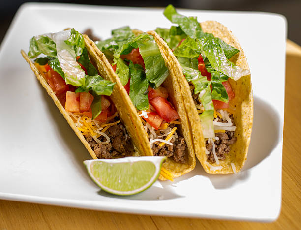istock Hard-shelled tacos with meat, cheese, lettuce, and tomato. 531403838
