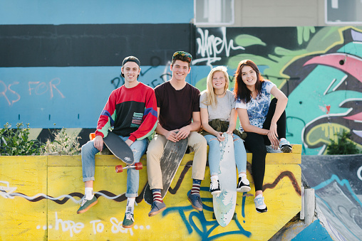 Group of teenagers relaxing & enjoying time together at the skate park.