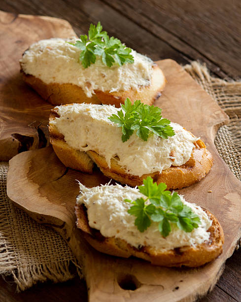 Toasted bread with a salted codfish mousse Toasted bread with a salted codfish mousse on wooden cutting board cinnamone stock pictures, royalty-free photos & images