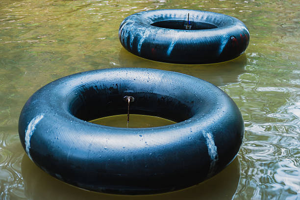Old inner tubes floating on a river Old inner tubes floating on a river, selective focus inflatable ring photos stock pictures, royalty-free photos & images