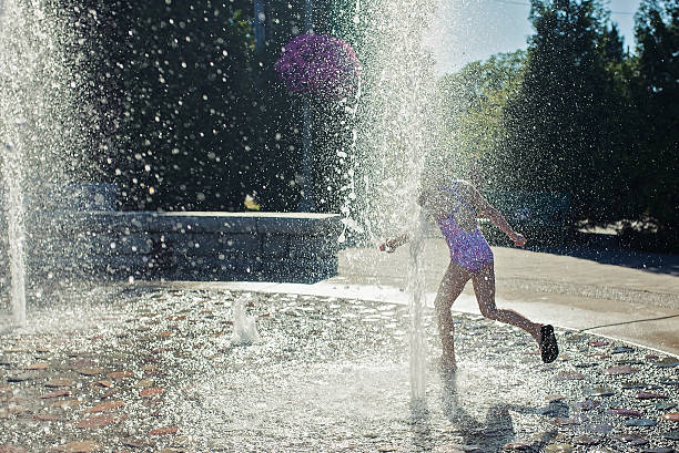 istock Young girl playing in a fountain . 531404970