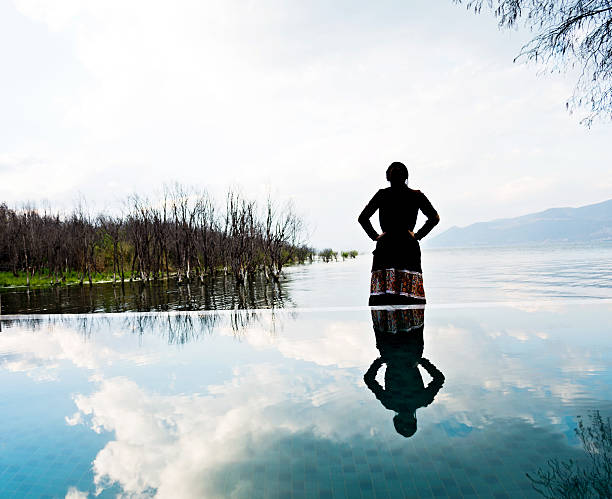 mujer joven parado en la bahía de agua - heaven women sunrise inspiration fotografías e imágenes de stock