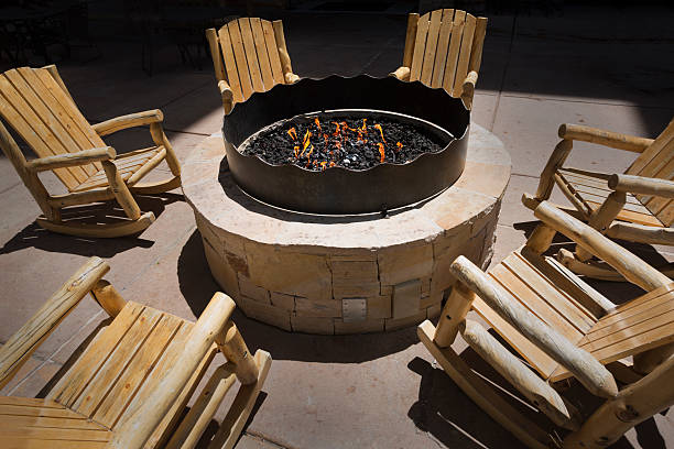 istock Large outdoor fire pit surrounded by wooden rocking chairs 531406416